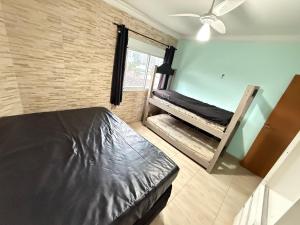 Un dormitorio con dos literas y una ventana. en Pé na areia canto do forte II, en Praia Grande