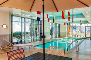 a swimming pool with chairs and an umbrella at Residence Inn by Marriott Boston Harbor on Tudor Wharf in Boston