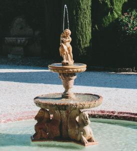 a fountain with two cherubs on it in a yard at Chateau de Paraza in Paraza