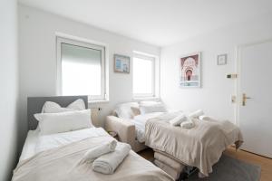 シュタイアーにあるSteyr Comfort Lodge Anytime Check In for Business and Familyのベッドが3つと窓が2つある部屋