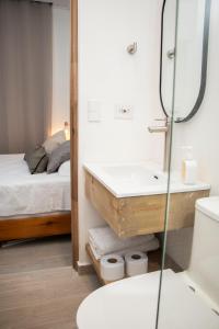 a bathroom with a sink and a mirror and a bed at Zenia 70 Living & Suites in Medellín