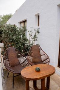 two wicker chairs and a table on a patio at Hostal La Torre Ibiza Cap Negret in San Antonio