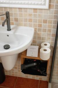 a bathroom with a sink and two rolls of toilet paper at Hostal La Torre Ibiza Cap Negret in San Antonio