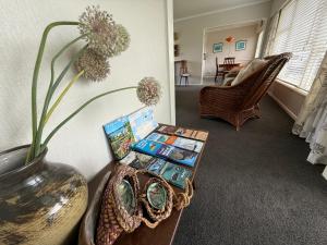 ラッセルにあるRetro Russell Retreat - Mins to Ferry, Beach, Eatsのリビングルーム(花瓶付きのテーブル付)