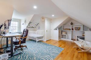 an attic room with a desk and a crib at Seaside Solstice HOT TUB, SAUNA 4 Bedroom in Scituate