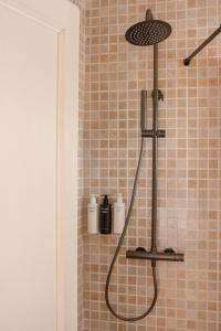 a shower with a shower head in a bathroom at Hostal La Torre Ibiza Cap Negret in San Antonio +37 photos