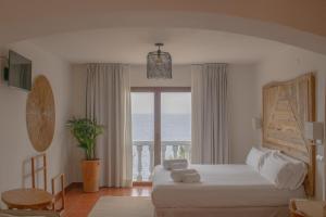 a bedroom with a bed and a view of the ocean at Hostal La Torre Ibiza Cap Negret in San Antonio
