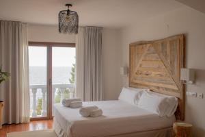 a bedroom with a bed with two towels on it at Hostal La Torre Ibiza Cap Negret in San Antonio