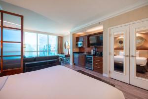a hotel room with a large bed and a balcony at No Resort Fee Strip View Suite +Free Valet + Pool in Las Vegas