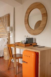 an orange refrigerator in front of a table with a mirror at Hostal La Torre Ibiza Cap Negret in San Antonio
