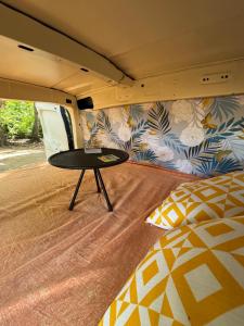 a room with a table in a camper with a bed at Van aménagé tout confort in Les Abymes