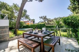 a wooden table and two benches on a patio at Cascais Villa - private pool in Cascais