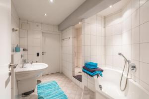 a white bathroom with a tub and a sink at Modern apartment, that's how you live in Lorsch +17 photos