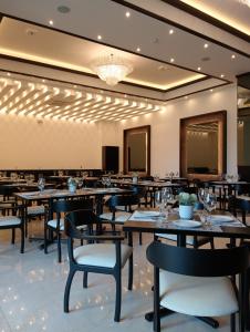 a dining room with tables and chairs and a chandelier at Ankara Pedregal Centro de Convenciones in San Luis Potosí