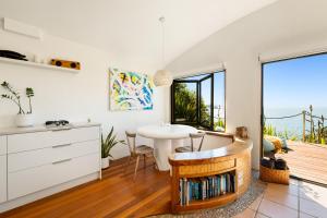 a kitchen with a table and a dining room at Crab Cove in Mahinepua