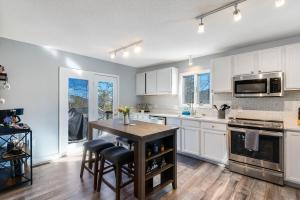 a kitchen with white cabinets and a wooden table at Mtn Views, Hot Tub, 2 Game Rms, Fire Pit, Pet Friendly, Top Mtn in McGaheysville