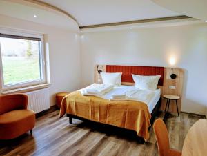 una camera da letto con un letto e una finestra di Hotel Tausendschön a Südbrookmerland