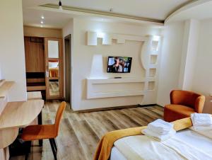una stanza con un letto e una TV su una parete di Hotel Tausendschön a Südbrookmerland