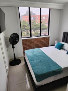 a bedroom with a bed and a large window at Habitación Coliving Marce Ibagué in Ibagué