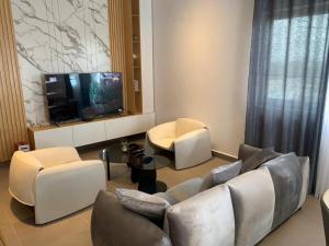 a living room with a couch and a flat screen tv at Résidences Maëlle fidjrossè Togbin in Cotonou