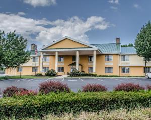 a large yellow building with a parking lot at Baymont by Wyndham Harrisburg in Harrisburg