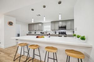 una cocina con una gran isla blanca con taburetes en Beautiful 3BD 2BATH Comfortable Home In Houston, en Houston
