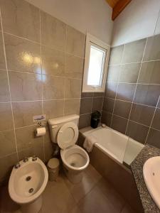 Un baño con inodoro, bañera y lavabo. en Blue House 6 Villa La Angostura, en Villa La Angostura 2 fotos más