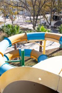 a blue and yellow water slide in a park at Hotel Pueblo Viejo in Parras de la Fuente