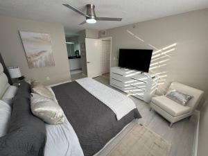 a bedroom with a bed and a tv and a chair at Urban Luxe Aventura 22 Retreat in Aventura