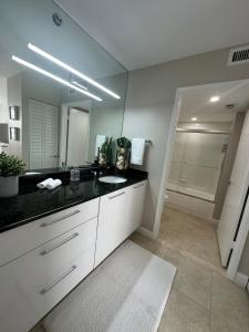 a bathroom with a sink and a large mirror at Urban Luxe Aventura 22 Retreat in Aventura