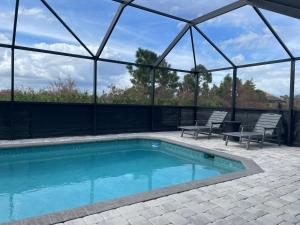 a swimming pool with two chairs and a glass house at DreamHome in Rotunda-West