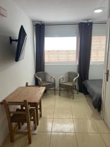 a room with a table and two chairs and a bed at Room with bathroom and kitchen in Sant Josep de Sa Talaia
