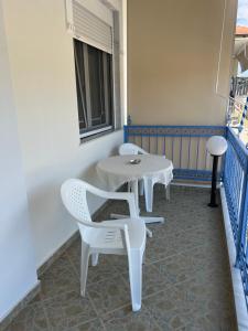 two white chairs and a table on a balcony at Seaside Apartment in Vergia in Vergia