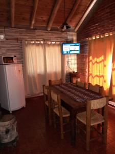 Un comedor con una mesa y un refrigerador. en Quinta Santiago, en San Rafael