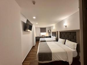 Postel nebo postele na pokoji v ubytování Hotel Bugari Aeropuerto Guadalajara + 37 fotografií