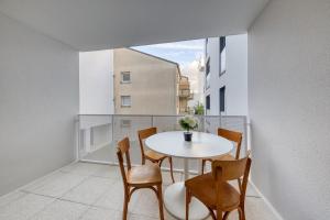 Zimmer mit einem Tisch und Stühlen auf einem Balkon in der Unterkunft En famille et à table, parking gratuit in Noisy-le-Sec