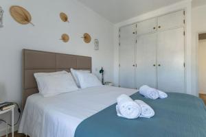 una camera da letto con un letto con asciugamani sopra di Timi's House - Espaçoso apartamento a 350 m da praia e centro da cidade velha ad Albufeira