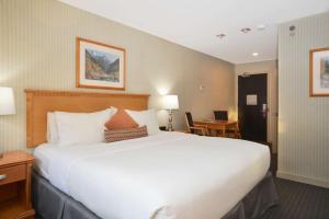a hotel room with a large bed and a desk at Listel Whistler, a Coast Hotel in Whistler