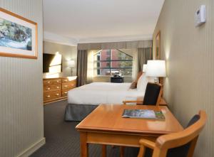 a hotel room with a bed and a desk with a laptop at Listel Whistler, a Coast Hotel in Whistler