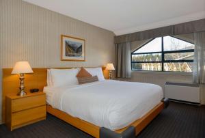 a hotel room with a large bed and a window at Listel Whistler, a Coast Hotel in Whistler
