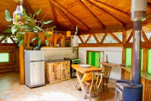 a kitchen with a table and a stove and a refrigerator at Cabanas Curi-Huapi in Isla Negra