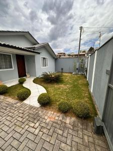 a backyard of a house with a brick driveway at Cozy house prox airport in São José dos Pinhais
