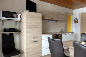 a small kitchen with a desk and a microwave at Apartment Milena in Nomenj