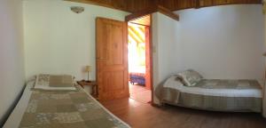 ein Schlafzimmer mit zwei Betten und einer Tür zu einem Fenster in der Unterkunft Nuestra Ruca in San Martín de los Andes