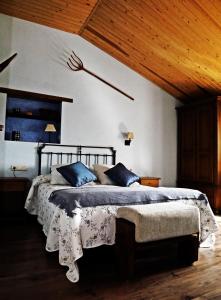 1 dormitorio con 1 cama grande con almohadas azules en Casa Lueza, en Alueza