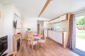 a kitchen and dining room with a table in a caravan at KustCamp Gamleby in Gamleby