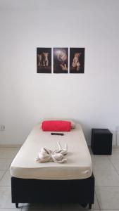 a bed in a room with pictures on the wall at Apartamento Brisa 202 in Pedra de Guaratiba