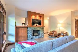 a living room with a blue couch and a fireplace at Nature Meets Luxury - Etoile 1520-3 in Mont-Tremblant