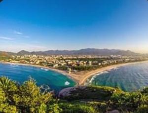 una vista aerea di una spiaggia con edifici e l'oceano di Apart 2 qdras da Praia do Recreio a Rio de Janeiro