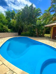 a large blue swimming pool in a yard at Paraíso Geribá in Búzios